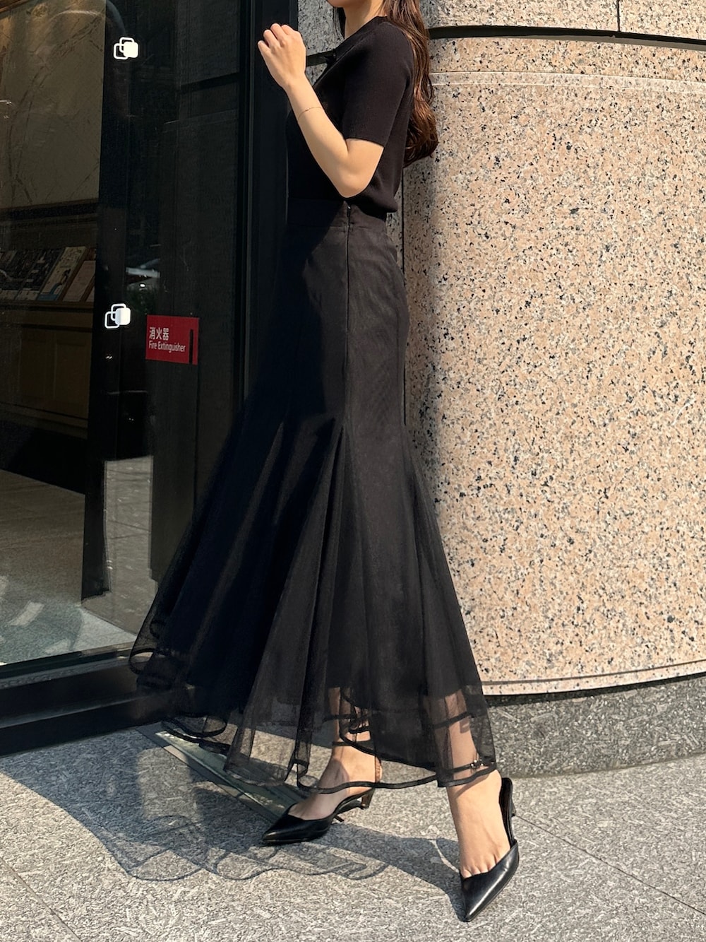 ブラック系のスカート、ブラック系のニット/セーターを着用したレディースの春コーディネートの2枚目の写真