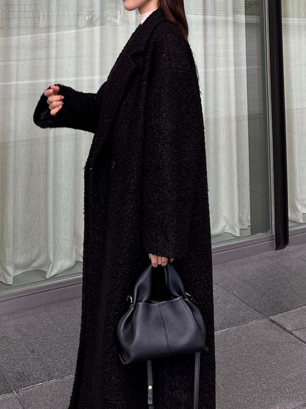 ブラック系のチェスターコート、ブラック系のスカートを着用したレディースの秋コーディネートの4枚目の写真