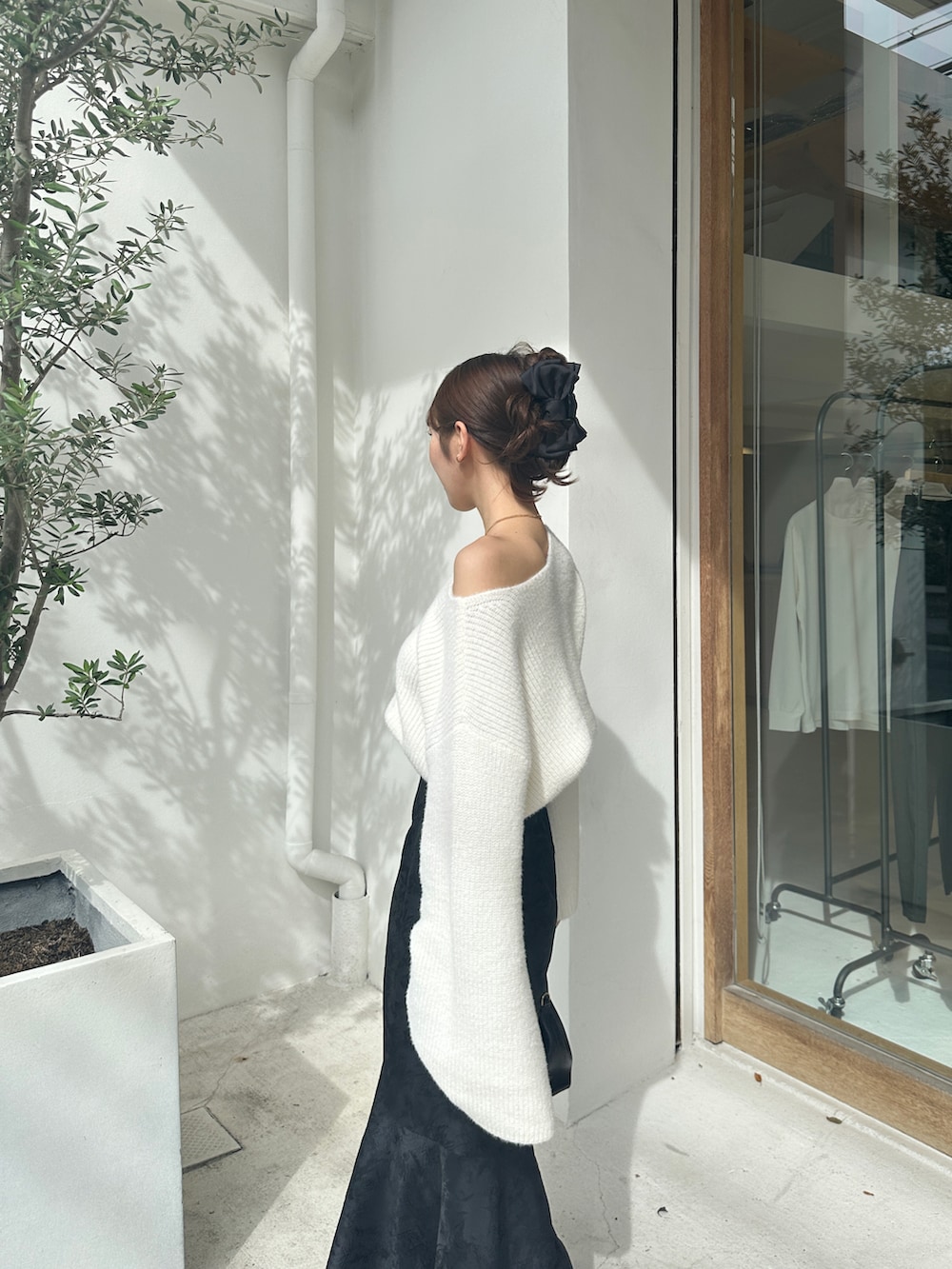 ホワイト系のニット/セーター、ブラック系のスカート、ブラック系のシューズを着用したレディースの秋コーディネートの3枚目の写真