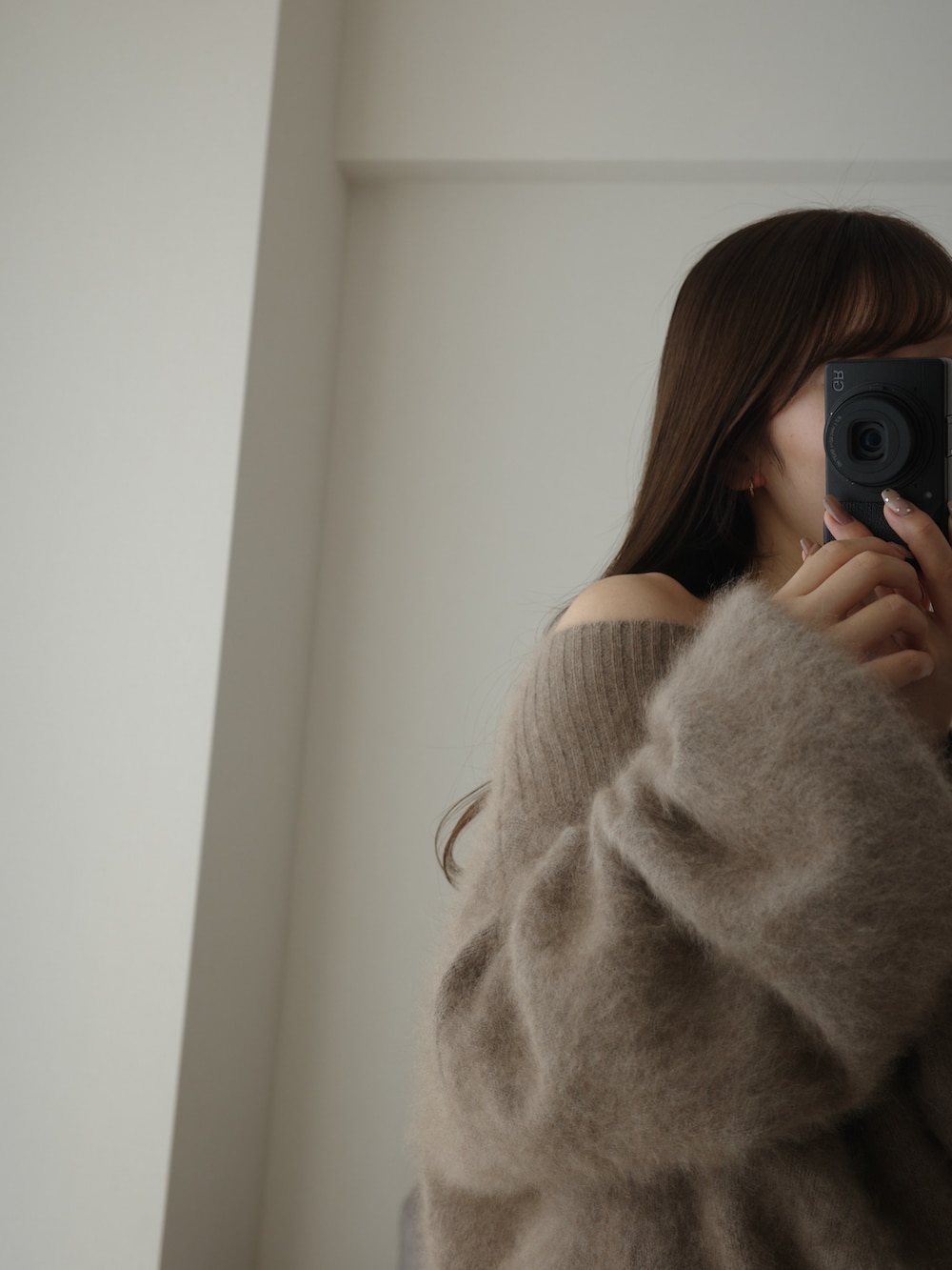 ホワイト系のスカート、ブラウン系のニット/セーターを着用したレディースの冬コーディネートの3枚目の写真