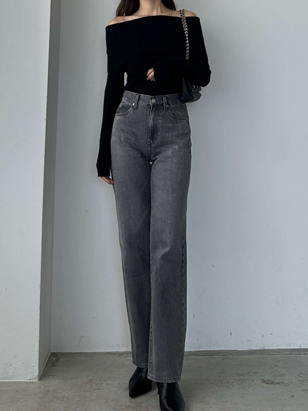 ブラック系のニット/セーター、グレー系のデニムパンツを着用したレディースの秋コーディネートの2枚目の写真