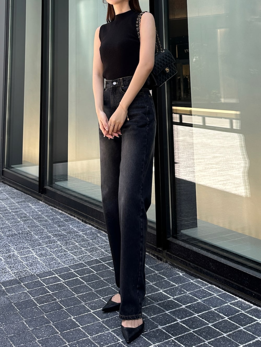 ブラック系のデニムパンツ、ブラック系のニット/セーターを着用したレディースの春コーディネートの2枚目の写真