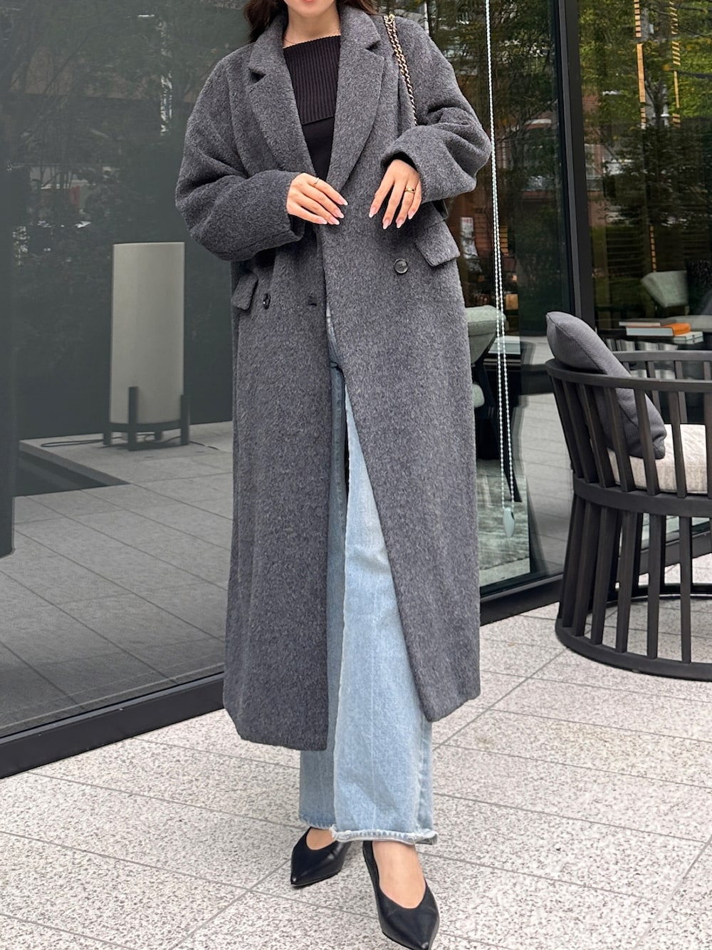 グレー系のチェスターコート、ブラック系のニット/セーターを着用したレディースの秋コーディネートの3枚目の写真