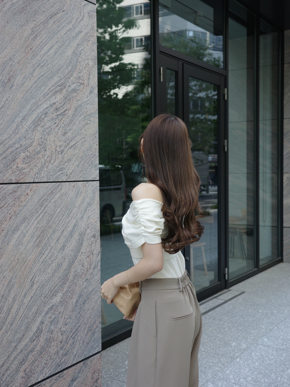 ホワイト系のニット/セーター、ベージュ系のスラックスを着用したレディースの春コーディネートの2枚目の写真