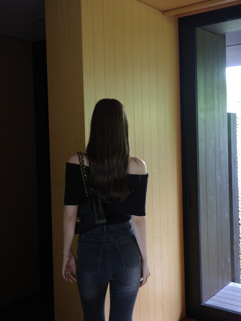 ブラック系のデニムパンツ、ブラック系のニット/セーターを着用したレディースの春コーディネートの5枚目の写真