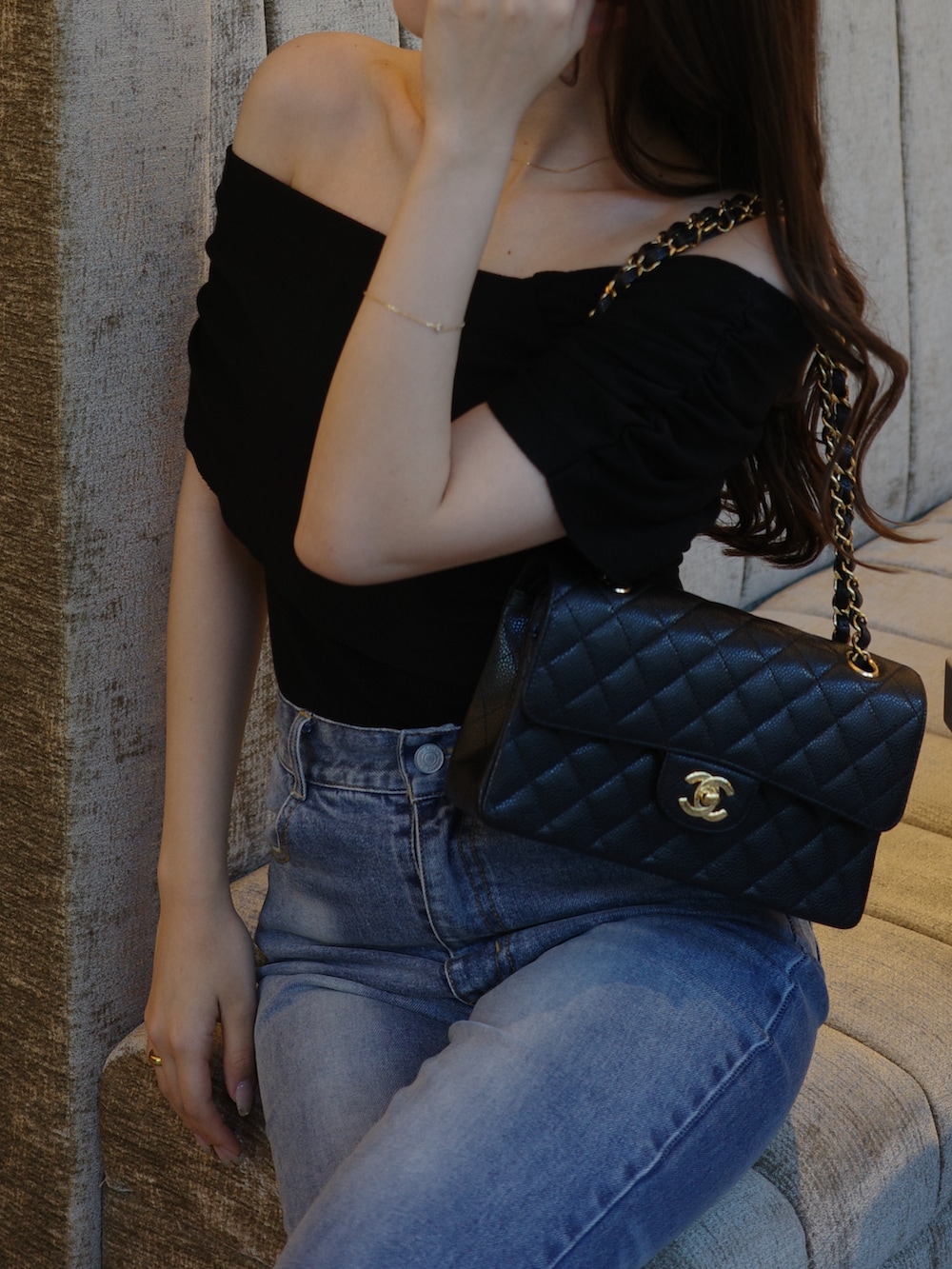 ブルー系のデニムパンツ、ブラック系のニット/セーターを着用したレディースの春コーディネートの4枚目の写真