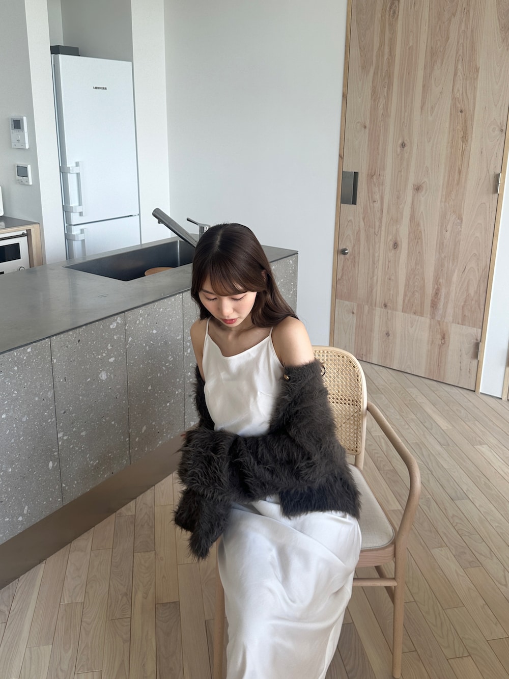 ブラウン系のカーディガン/ボレロ、ホワイト系のワンピースを着用したレディースの秋コーディネートの2枚目の写真