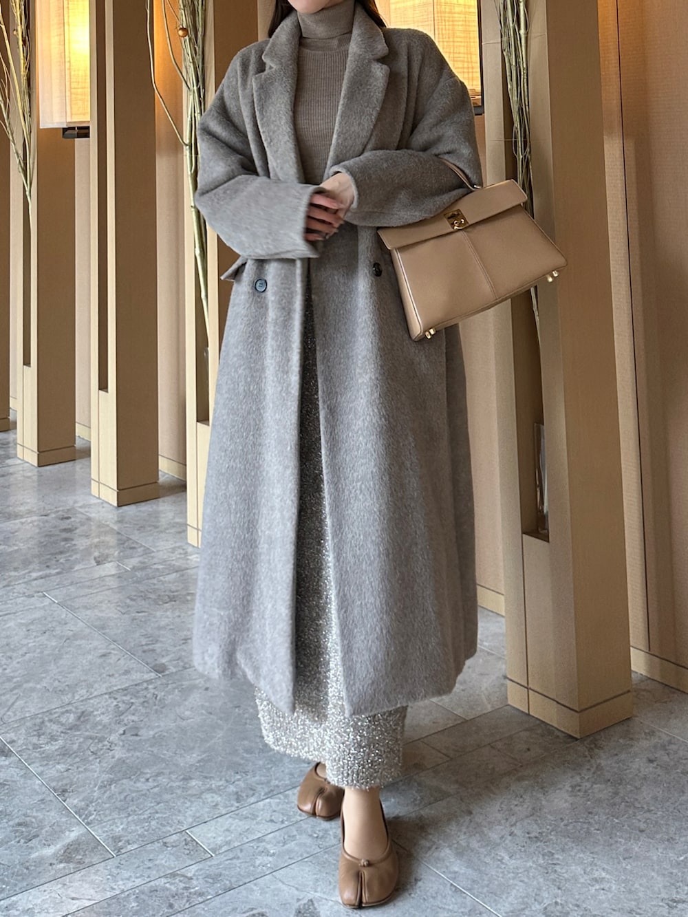 ブラウン系のチェスターコート、ベージュ系のスカートを着用したレディースの冬コーディネートの3枚目の写真