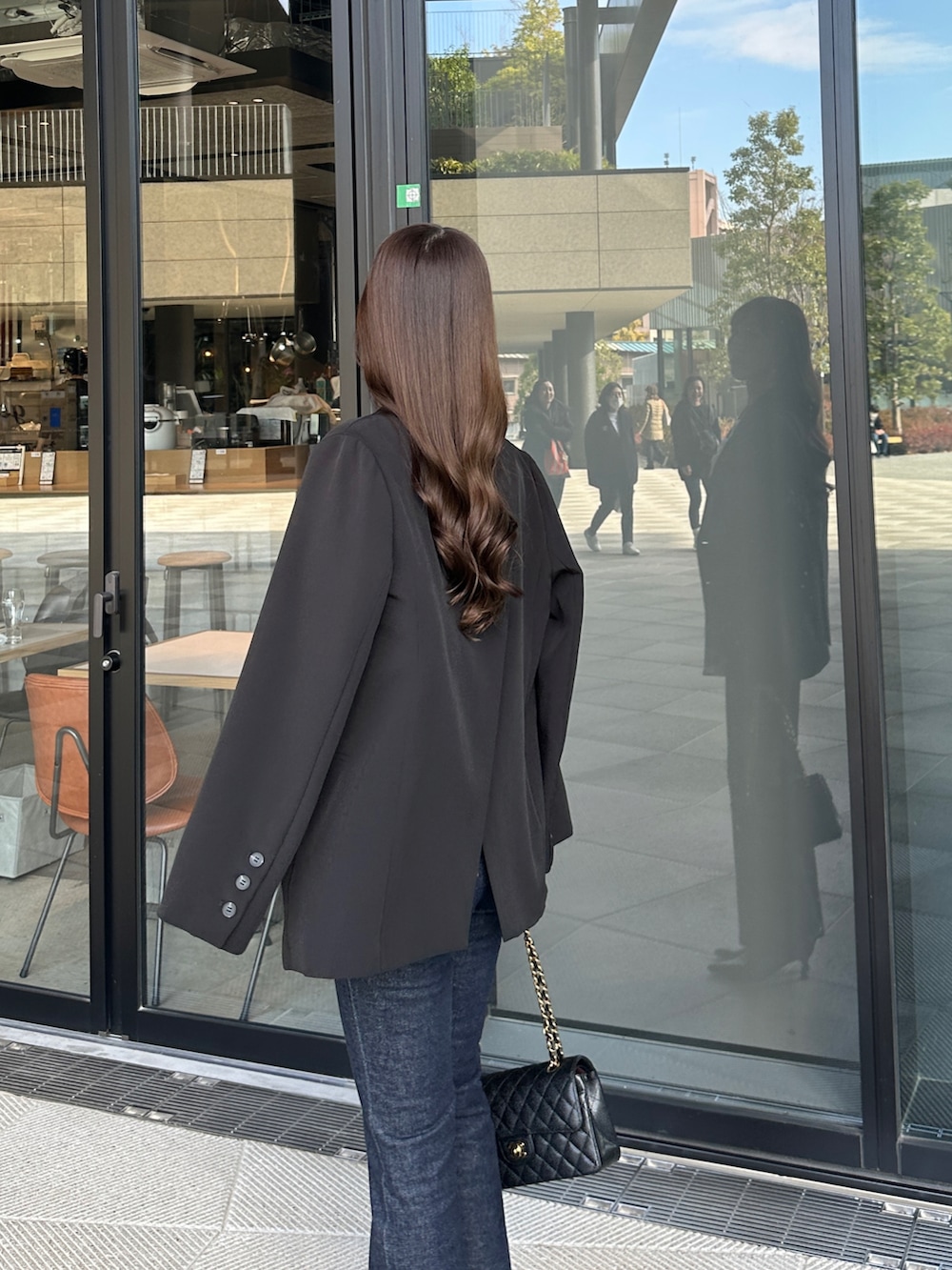 ブラック系のテーラードジャケットを着用したレディースの冬コーディネートの3枚目の写真