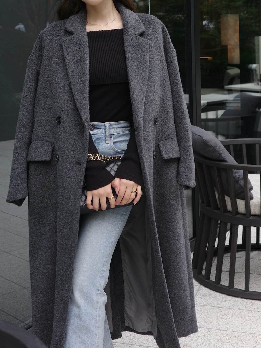 グレー系のチェスターコート、ブラック系のニット/セーターを着用したレディースの秋コーディネートの2枚目の写真