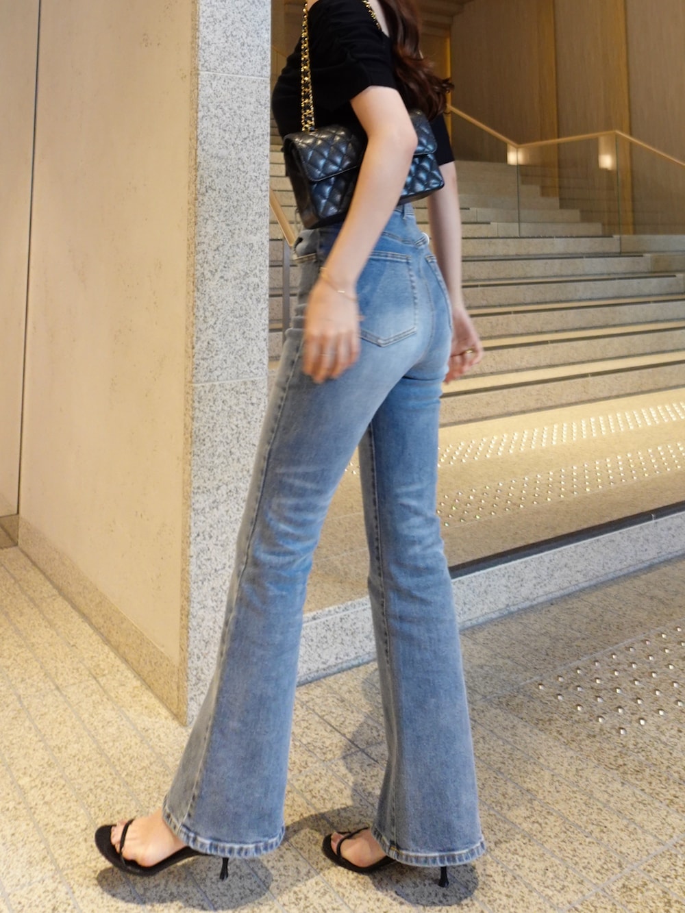 ブルー系のデニムパンツ、ブラック系のニット/セーターを着用したレディースの春コーディネートの3枚目の写真