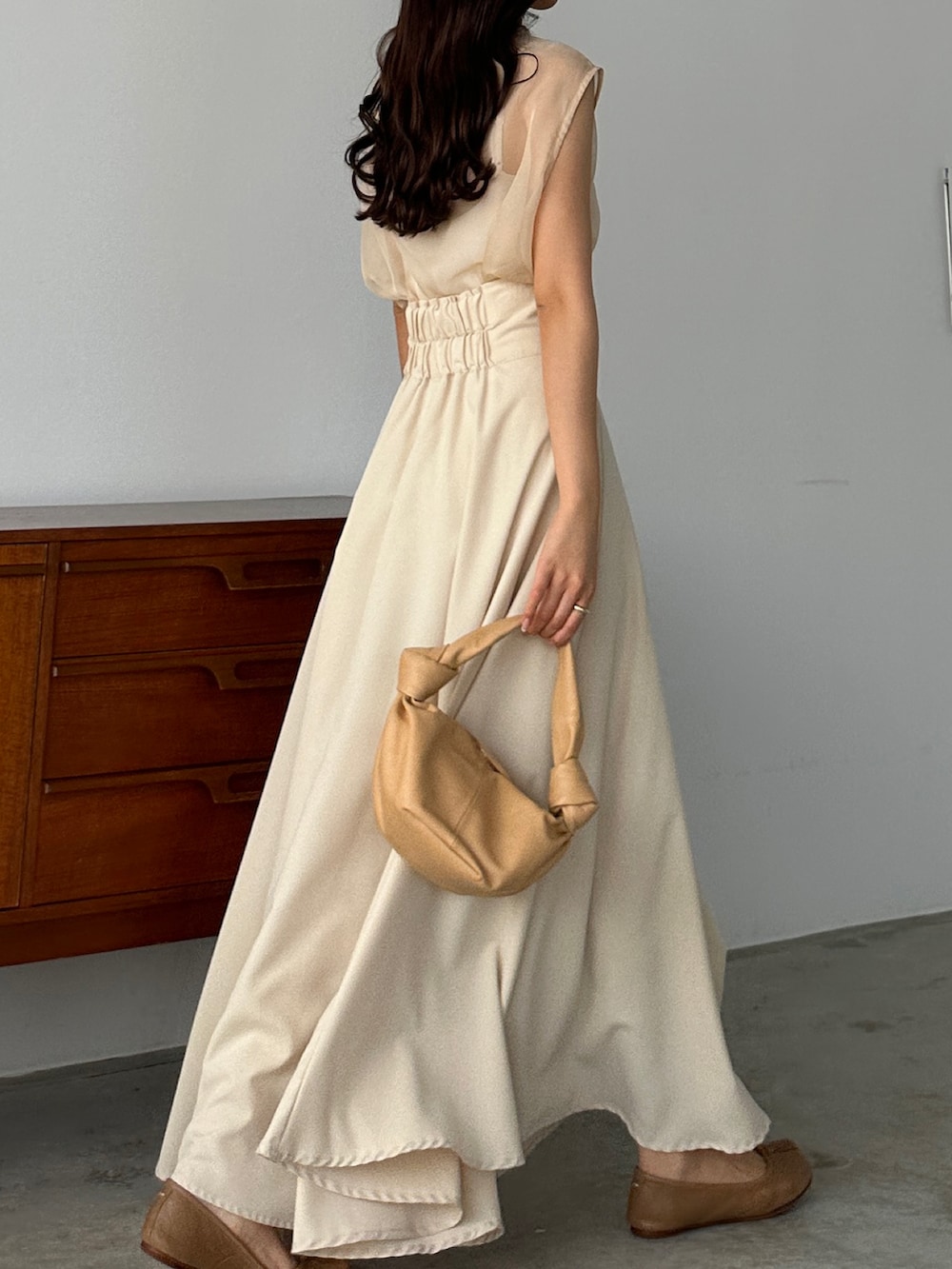 ベージュ系のスカート、ホワイト系のシャツ/ブラウス、ベージュ系のバッグを着用したレディースの春コーディネートの3枚目の写真