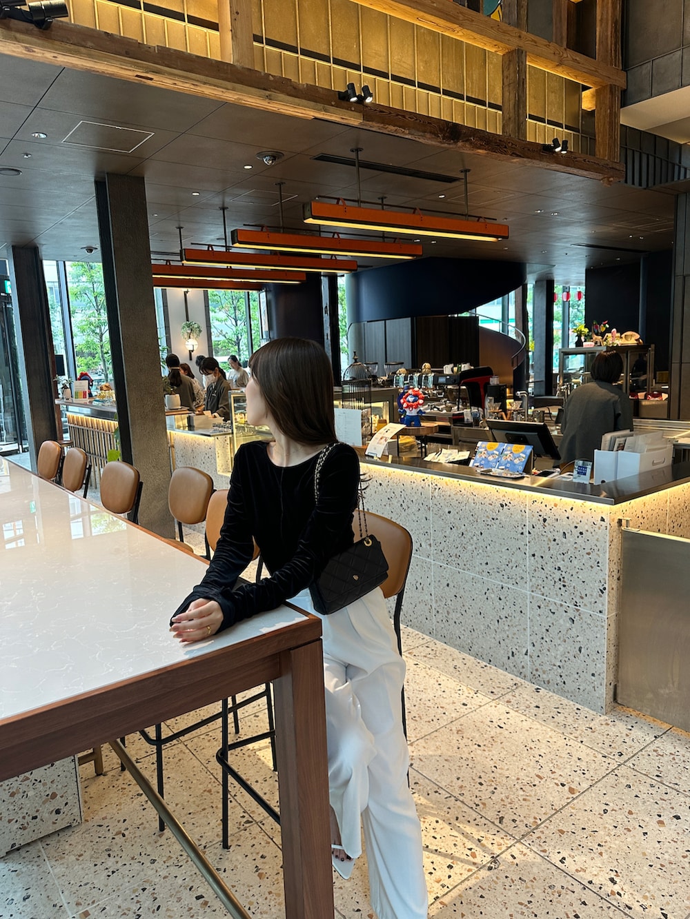 ホワイト系のパンツ、ブラック系のTシャツ/カットソーを着用したレディースの秋コーディネートの2枚目の写真