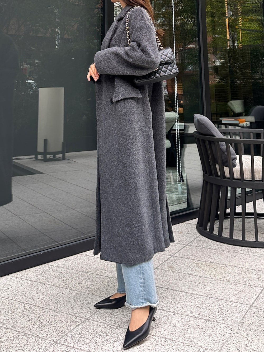 グレー系のチェスターコート、ブラック系のニット/セーターを着用したレディースの秋コーディネートの4枚目の写真