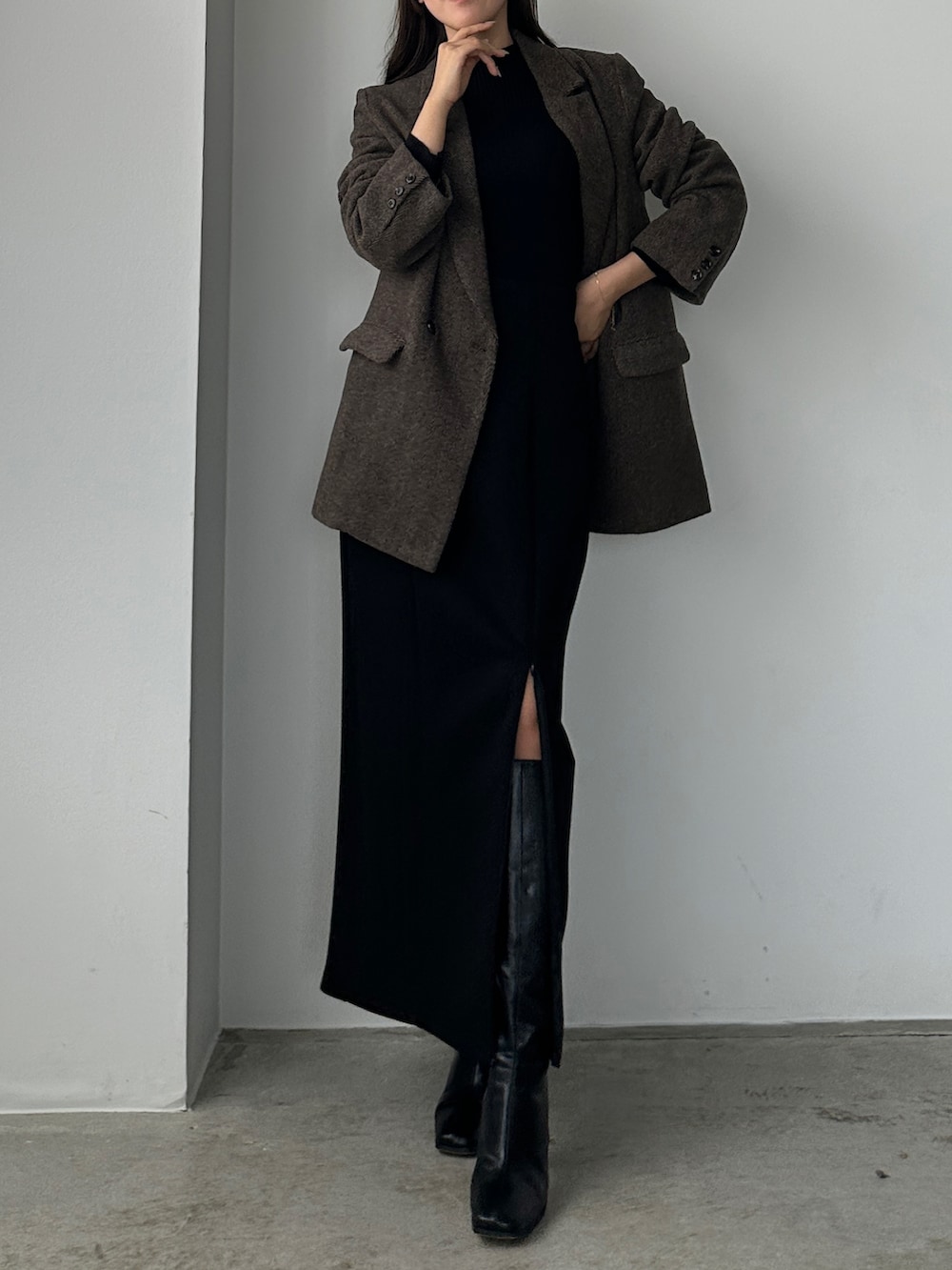 ブラック系のニット/セーター、ブラウン系のセットアップ、ブラック系のスカートを着用したレディースの秋コーディネートの2枚目の写真