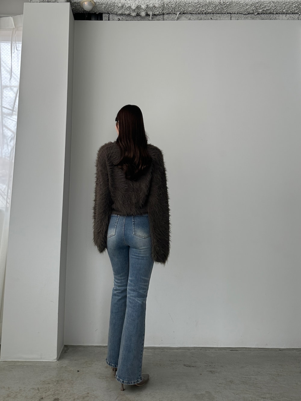 ブルー系のデニムパンツ、ブラウン系のカーディガン/ボレロを着用したレディースの秋コーディネートの2枚目の写真