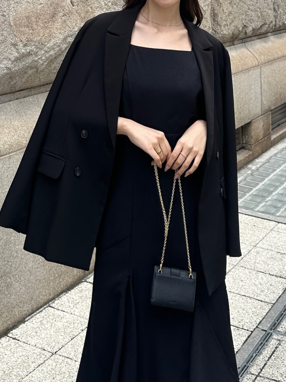 ブラック系のワンピース、ブラック系のテーラードジャケットを着用したレディースの春コーディネートの2枚目の写真