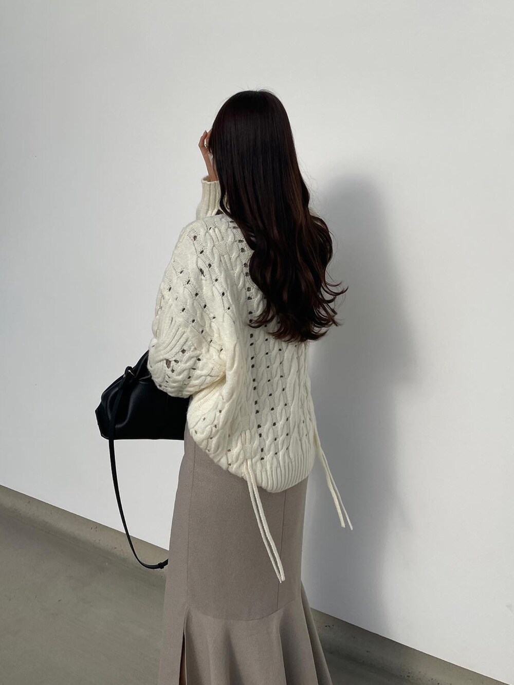 ホワイト系のニット/セーター、ブラウン系のスカート、ベージュ系のマフラーを着用したレディースの冬コーディネートの4枚目の写真