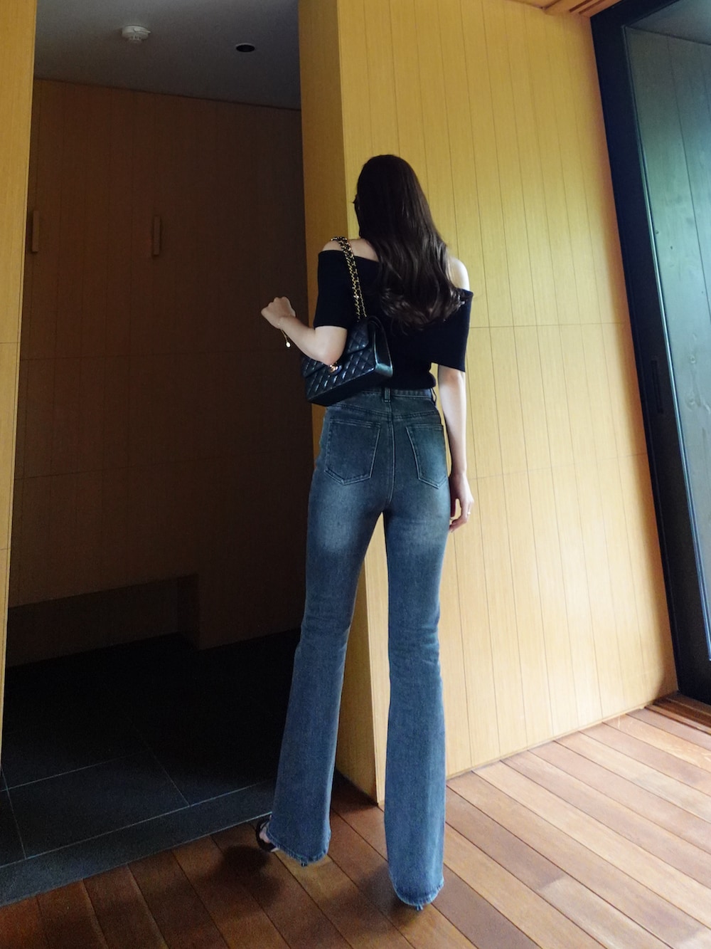ブラック系のデニムパンツ、ブラック系のニット/セーターを着用したレディースの春コーディネートの3枚目の写真