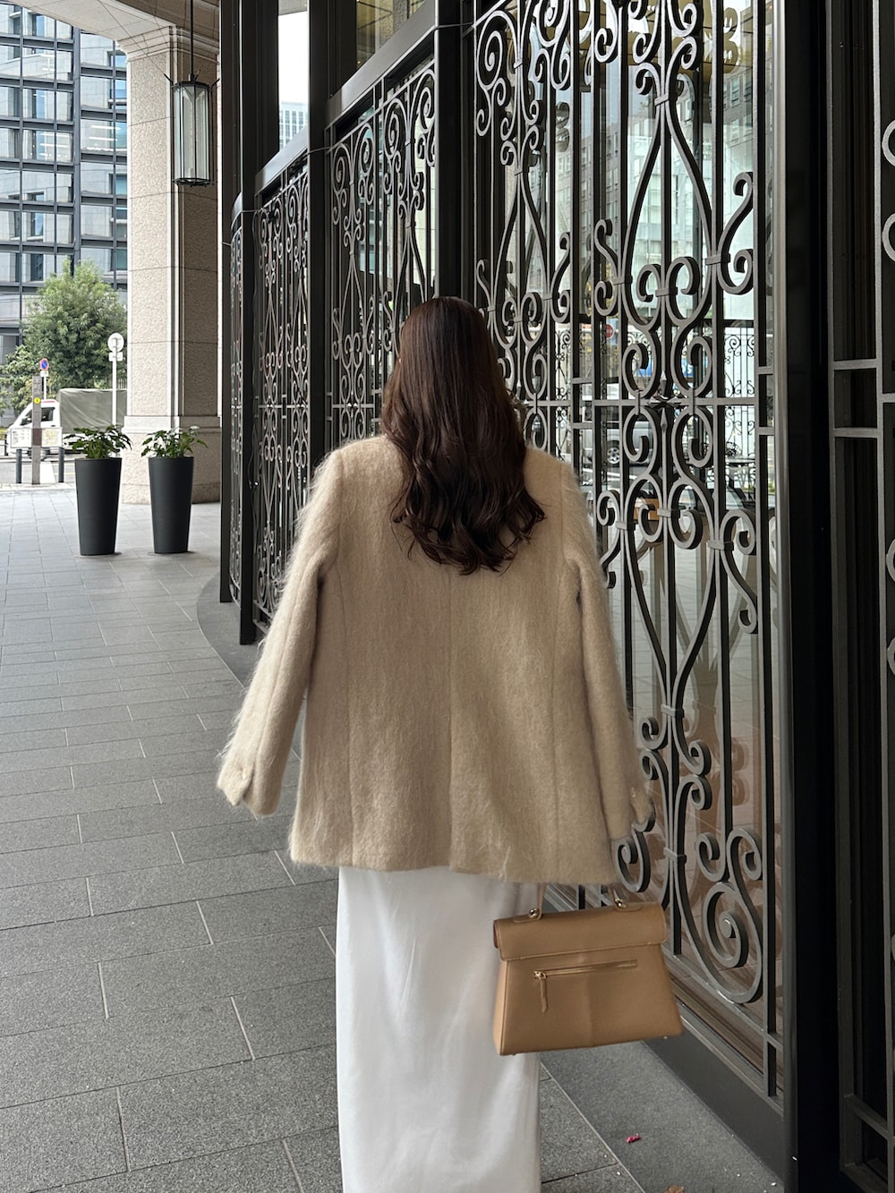 ベージュ系のテーラードジャケット、ベージュ系のハンドバッグを着用したレディースの冬コーディネートの4枚目の写真