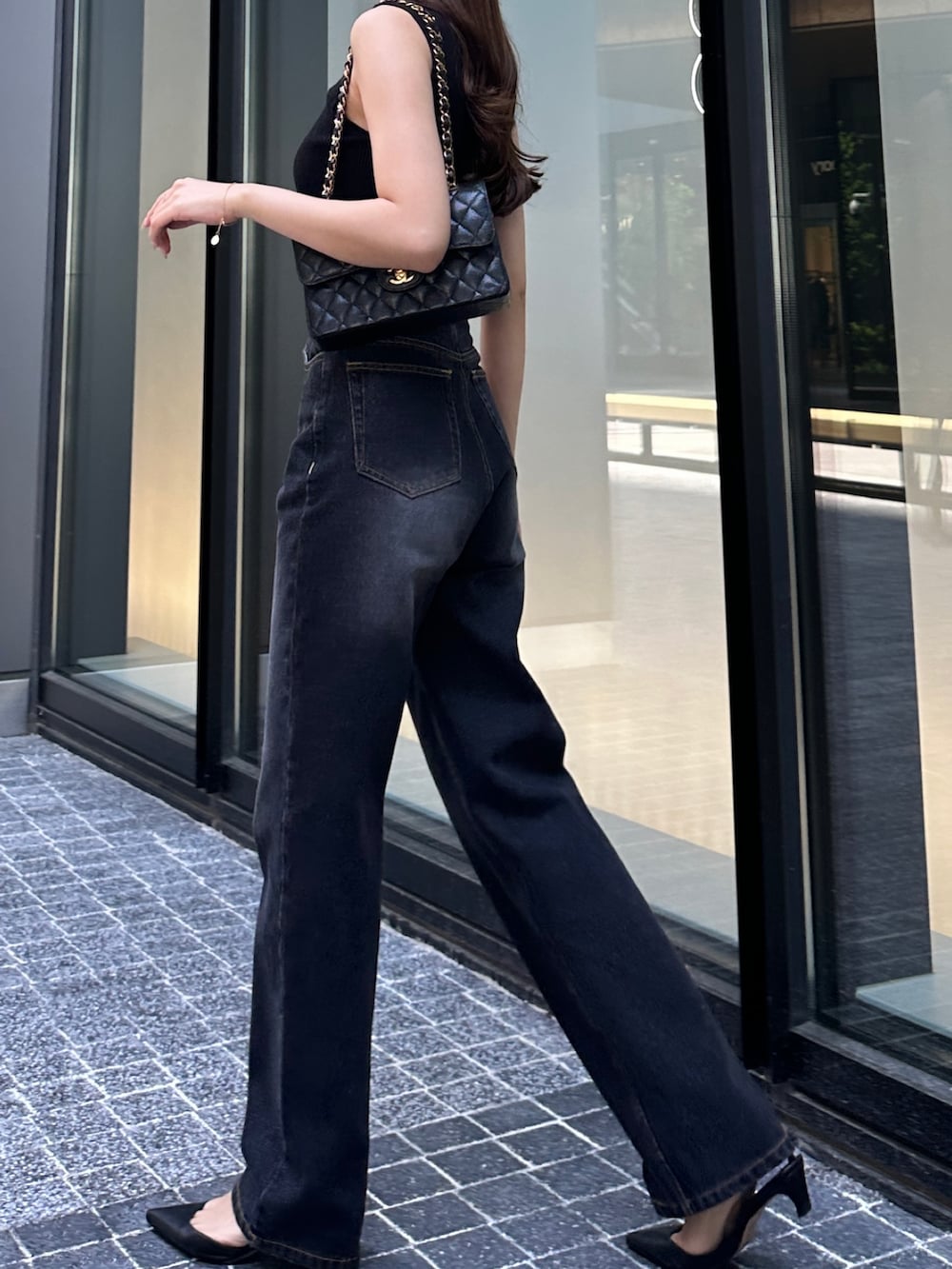 ブラック系のデニムパンツ、ブラック系のニット/セーターを着用したレディースの春コーディネートの3枚目の写真