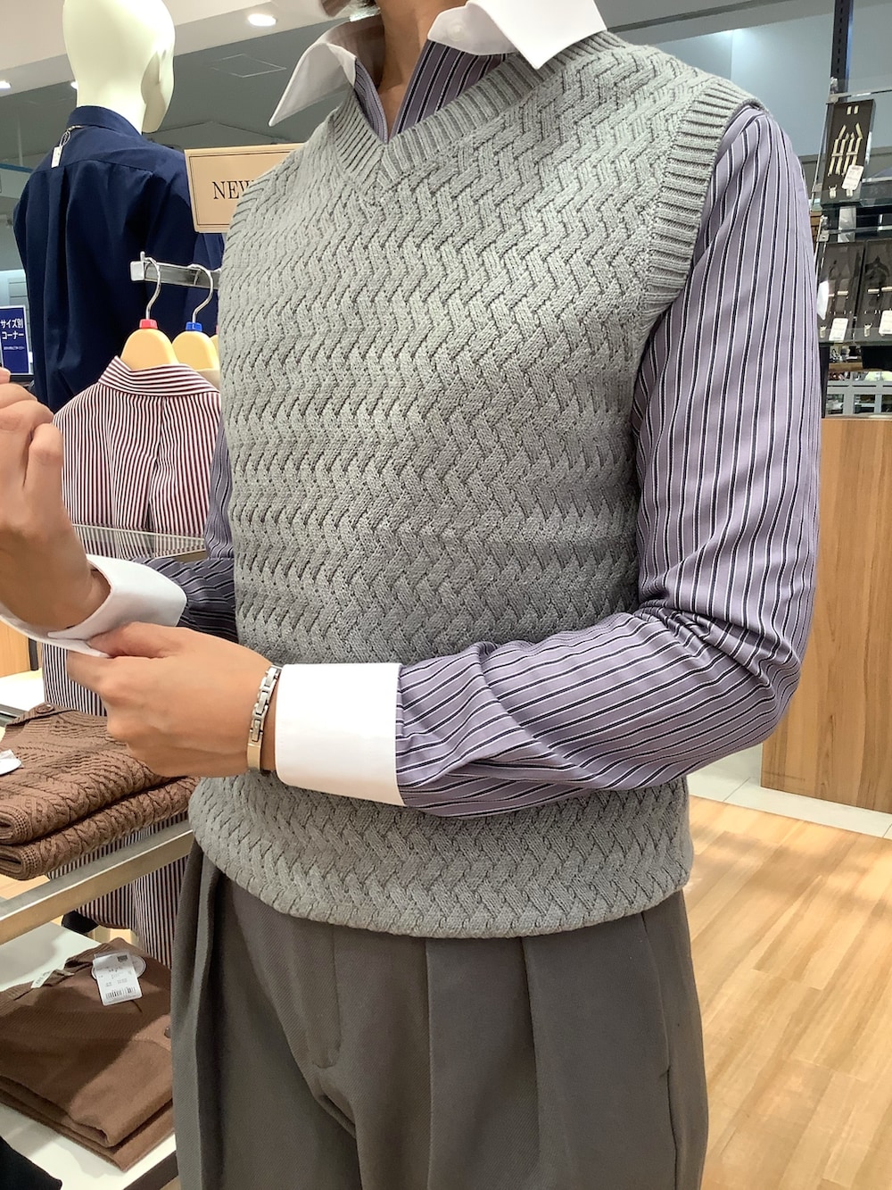 グレー系のニット/セーター、グレー系のビジネスシャツを着用したレディースの冬コーディネートの2枚目の写真