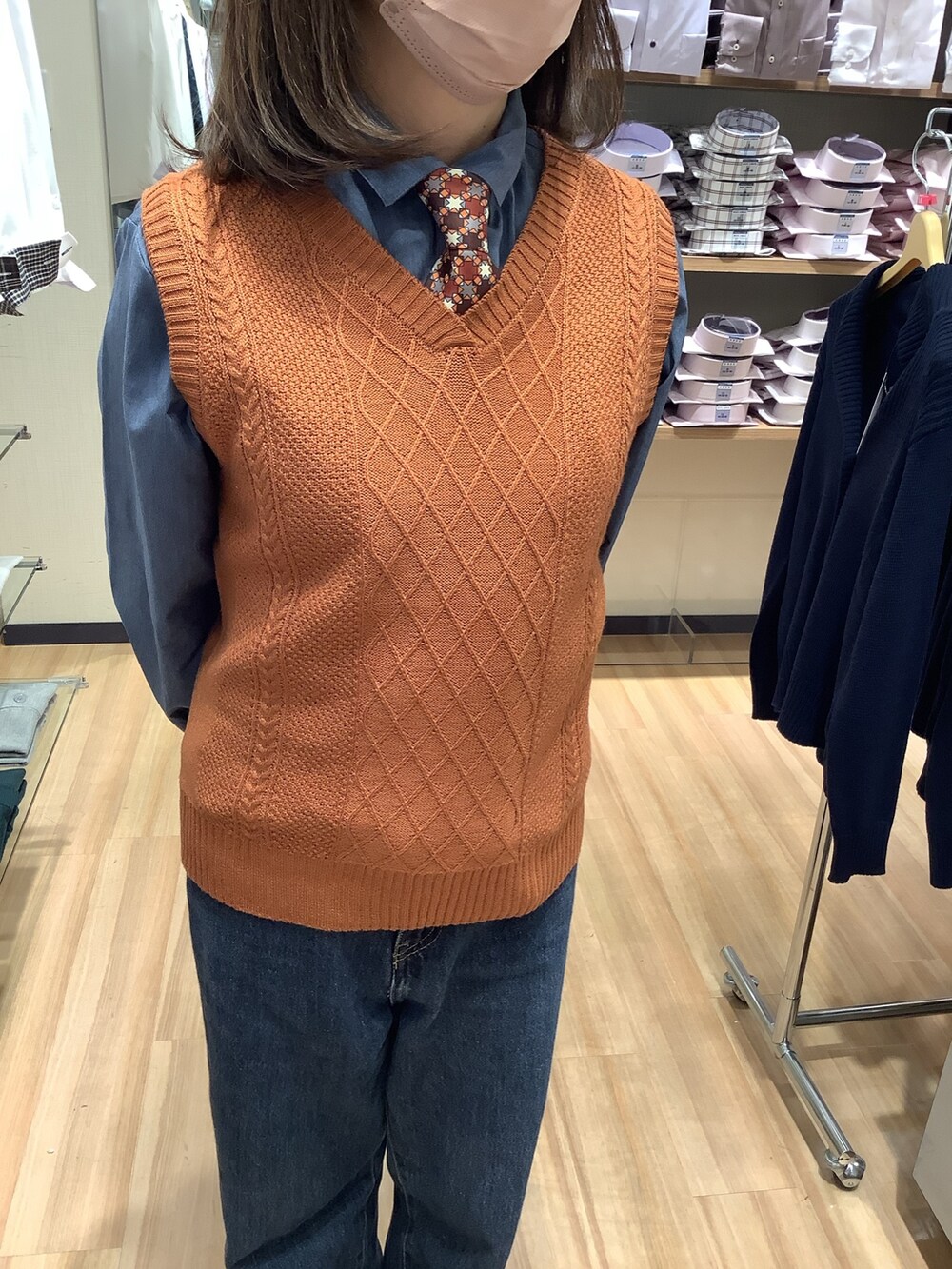 オレンジ系のベスト、ブルー系のシャツ/ブラウス、その他のネクタイを着用したレディースの冬コーディネートの2枚目の写真