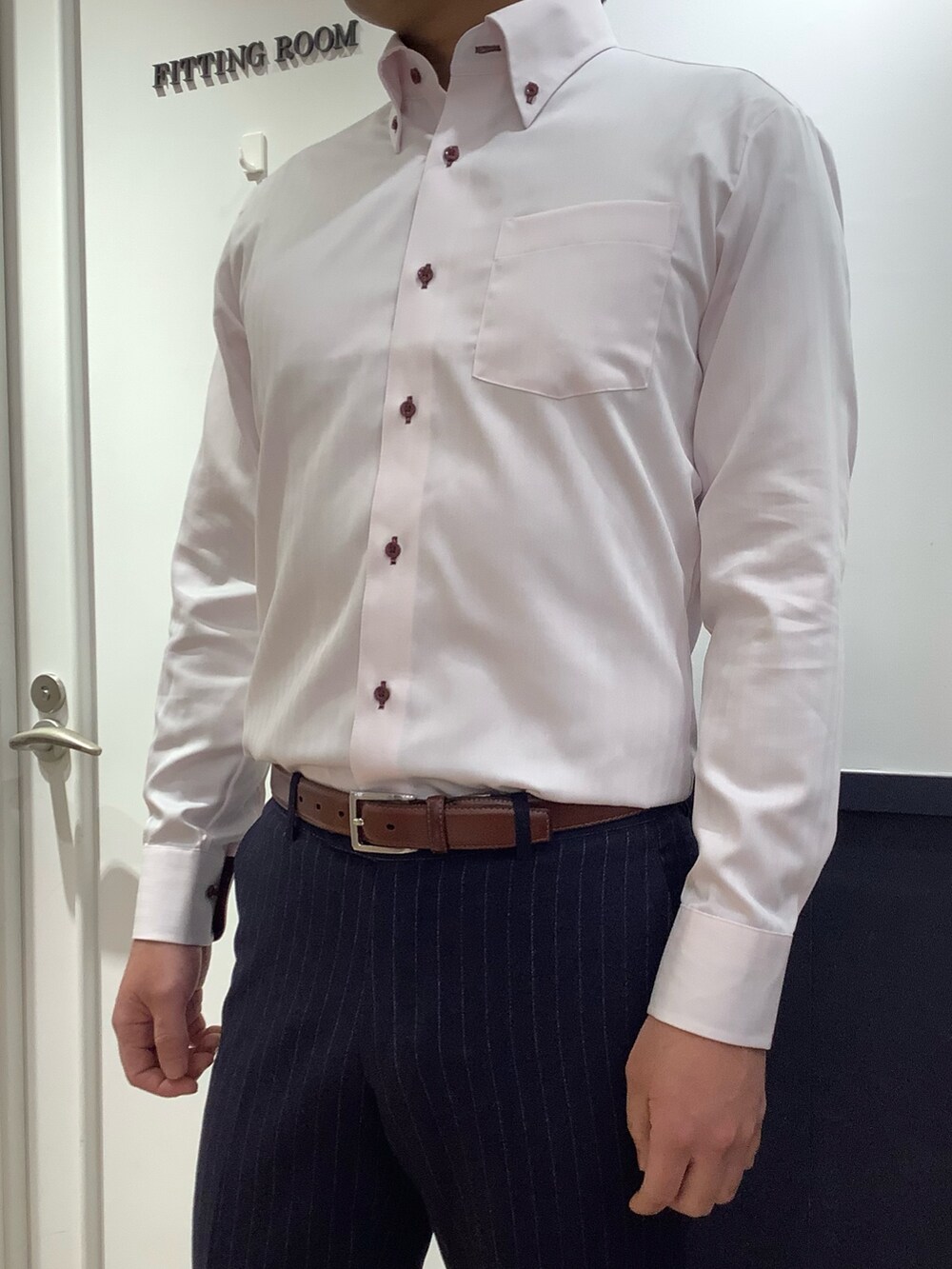 ピンク系のビジネスシャツを着用したメンズの冬コーディネートの2枚目の写真