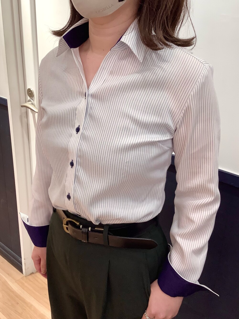 ブルー系のビジネスシャツを着用したレディースの夏コーディネートの2枚目の写真