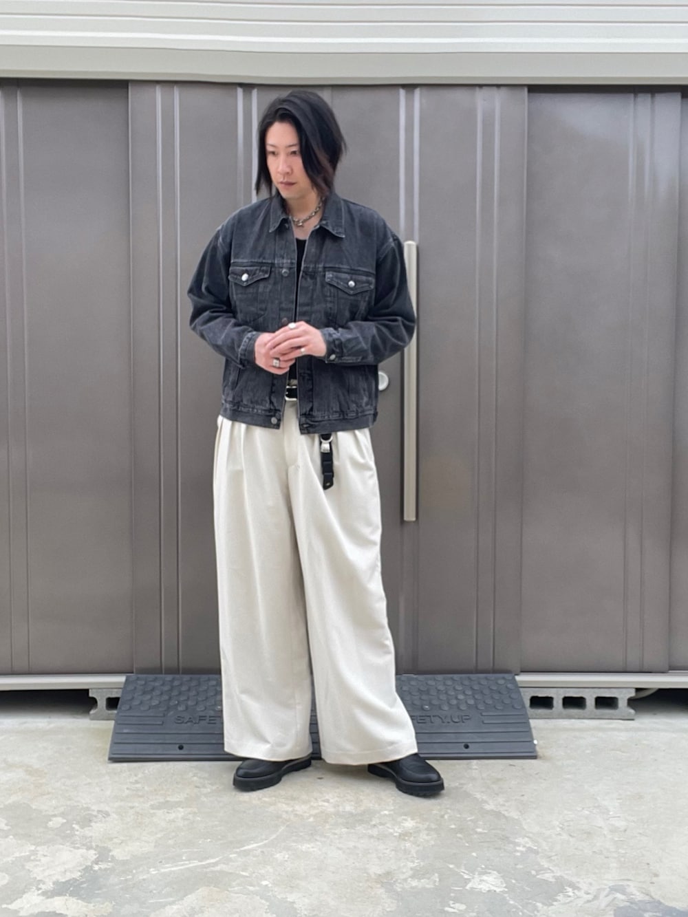 ブラック系のデニムジャケット、ホワイト系のスラックス、ブラック系のドレスシューズを着用したメンズの秋コーディネートの4枚目の写真