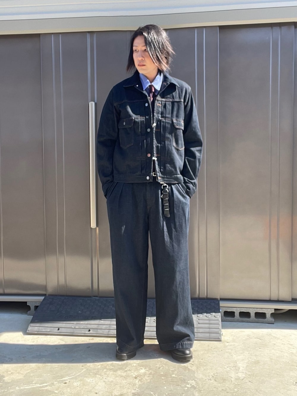 ブルー系のデニムジャケット、ブルー系のデニムパンツ、ブラック系のドレスシューズを着用したメンズの秋コーディネートの2枚目の写真