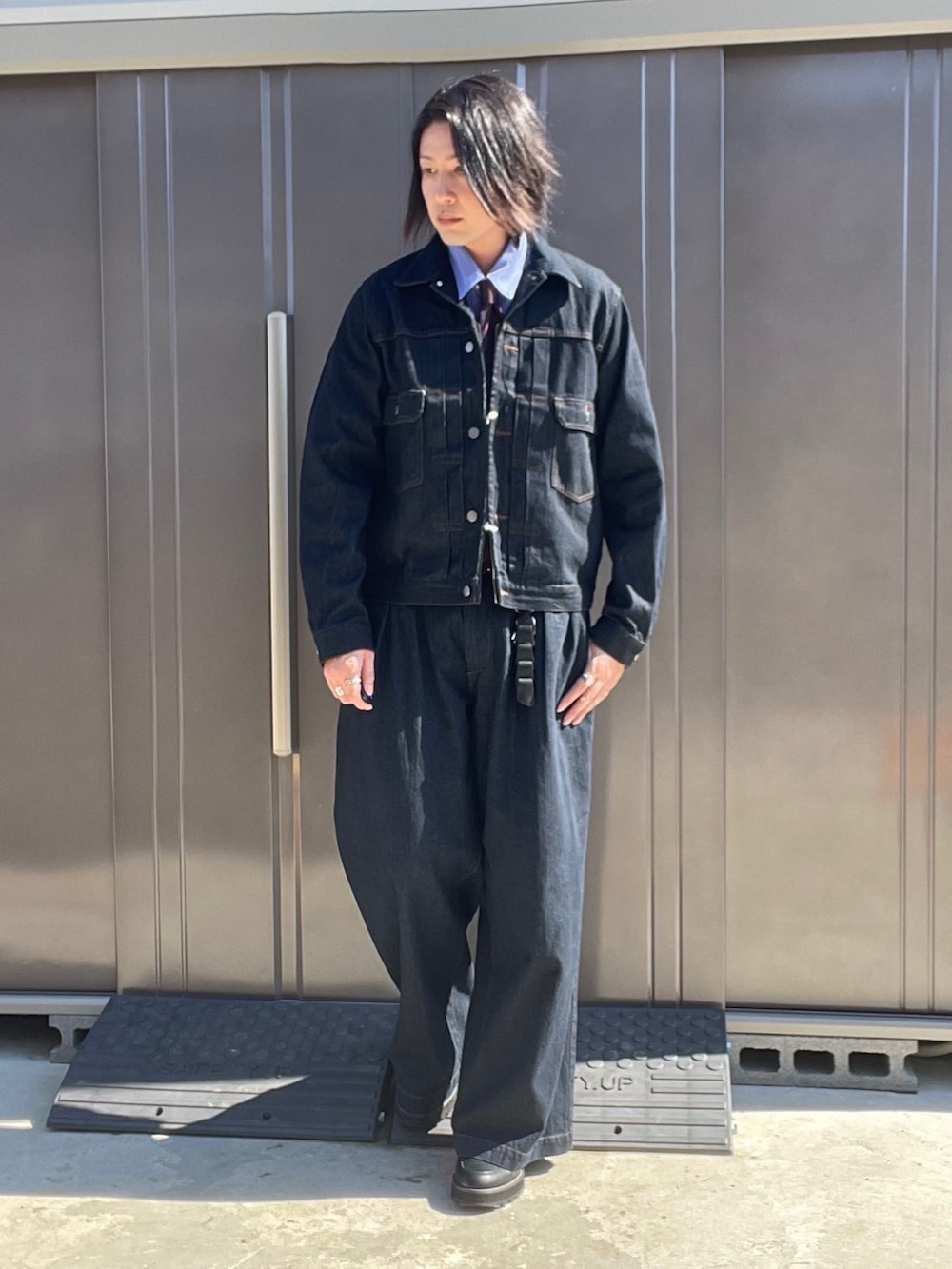 ブルー系のデニムジャケット、ブルー系のデニムパンツ、ブラック系のドレスシューズを着用したメンズの秋コーディネートの4枚目の写真