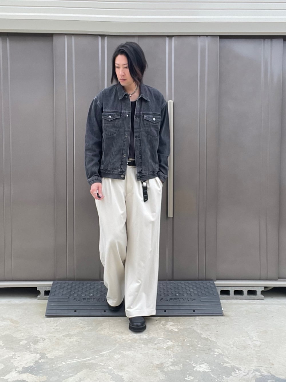 ブラック系のデニムジャケット、ホワイト系のスラックス、ブラック系のドレスシューズを着用したメンズの秋コーディネートの3枚目の写真