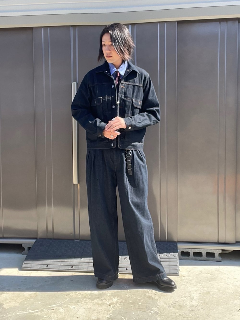 ブルー系のデニムジャケット、ブルー系のデニムパンツ、ブラック系のドレスシューズを着用したメンズの秋コーディネートの3枚目の写真