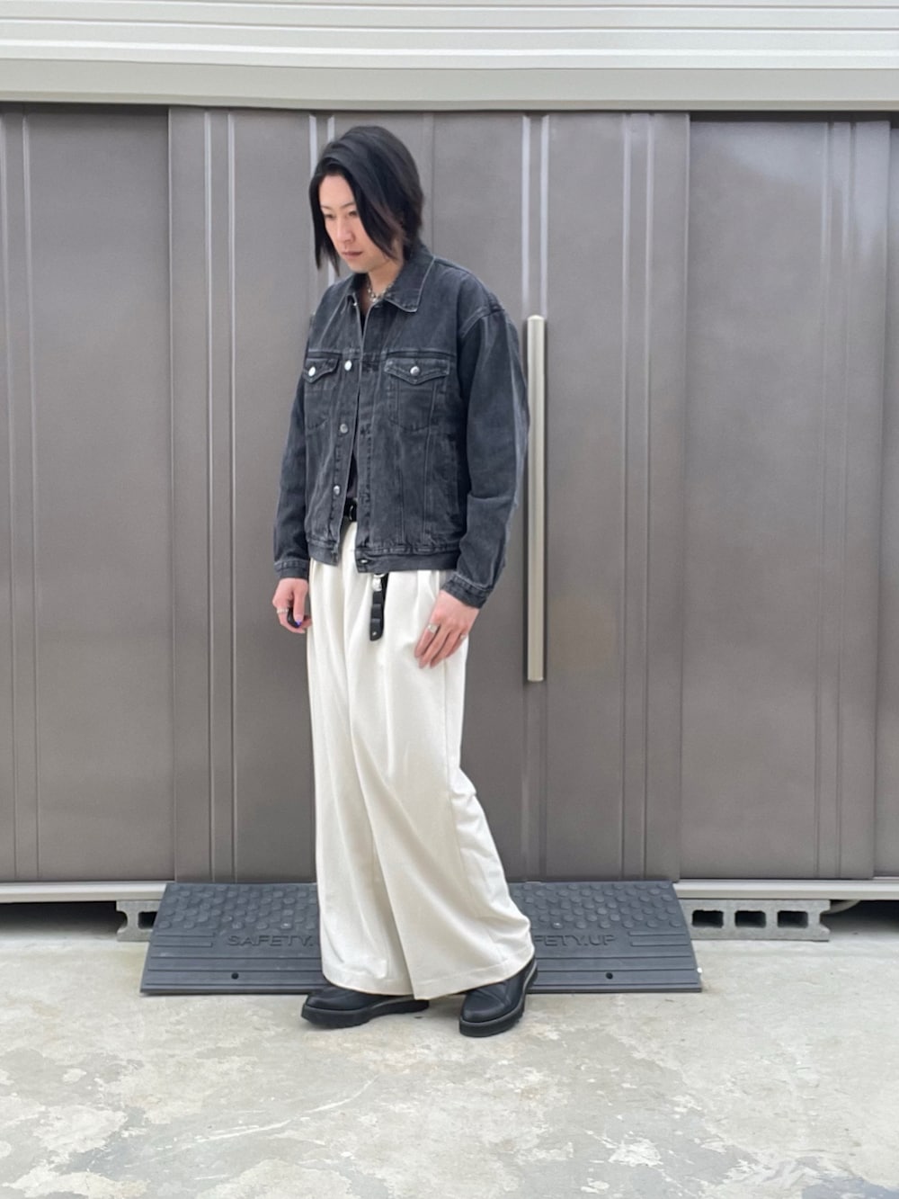 ブラック系のデニムジャケット、ホワイト系のスラックス、ブラック系のドレスシューズを着用したメンズの秋コーディネートの5枚目の写真