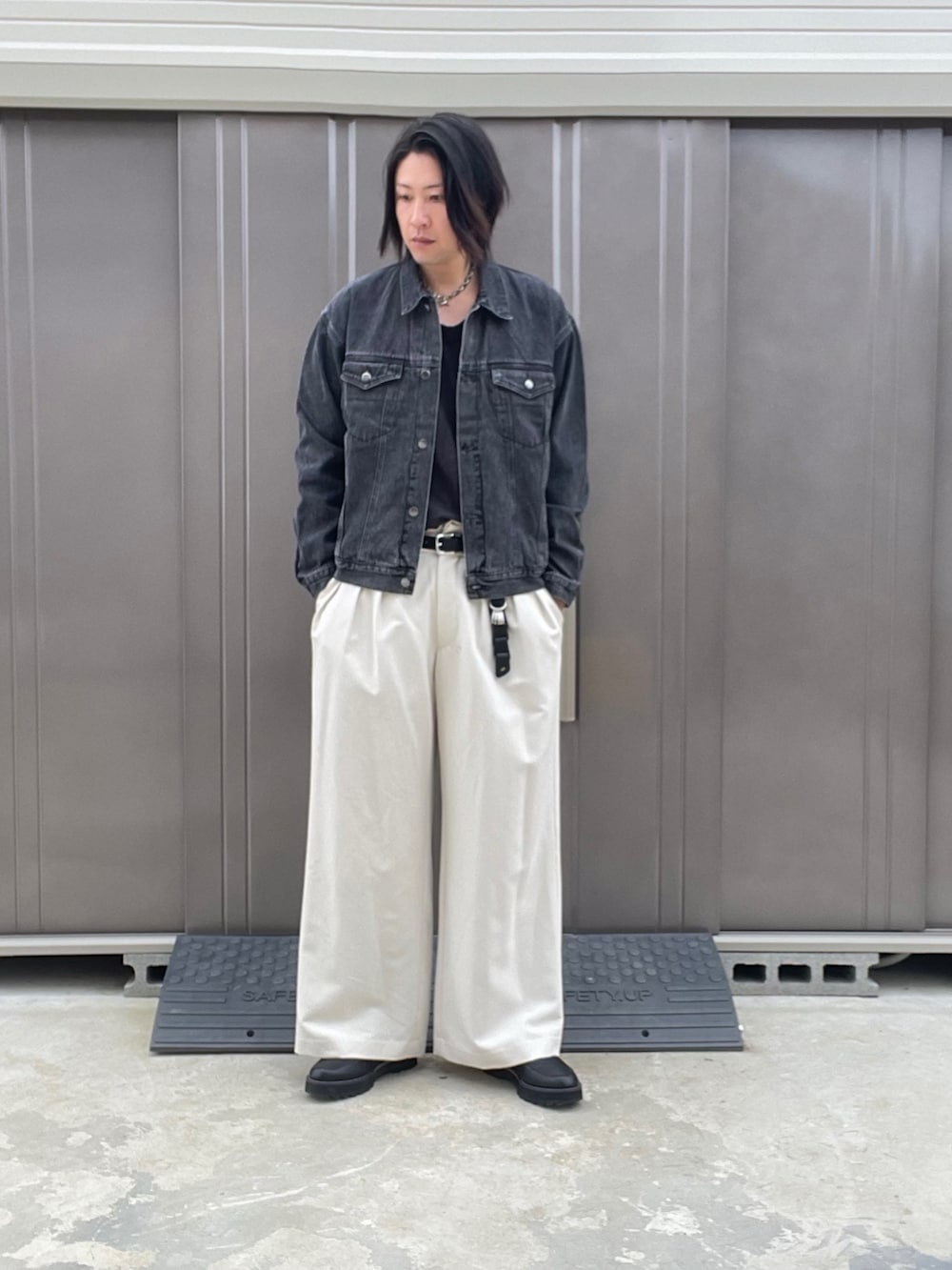 ブラック系のデニムジャケット、ホワイト系のスラックス、ブラック系のドレスシューズを着用したメンズの秋コーディネートの2枚目の写真