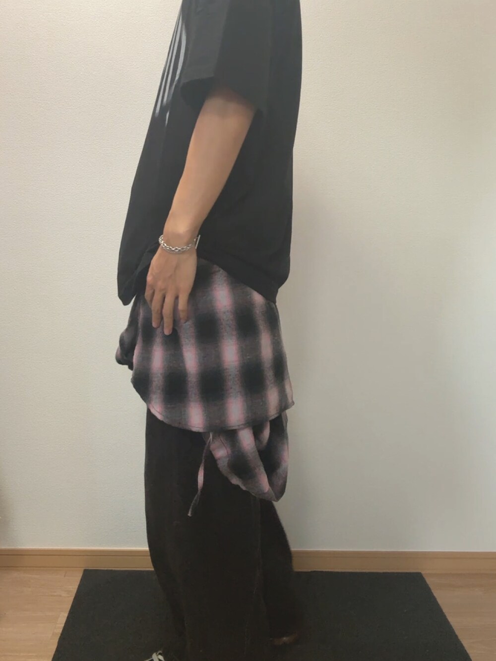 ブラック系のデニムパンツ、ブラック系のTシャツ/カットソー、ブラック系のスニーカーを着用したメンズの春コーディネートの2枚目の写真