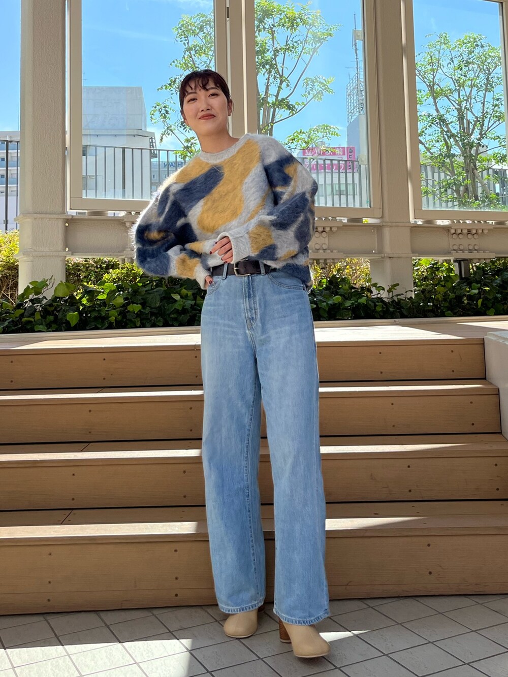 ブルー系のニット/セーター、ブルー系のデニムパンツ、ベージュ系のブーツを着用したレディースの秋コーディネートの2枚目の写真