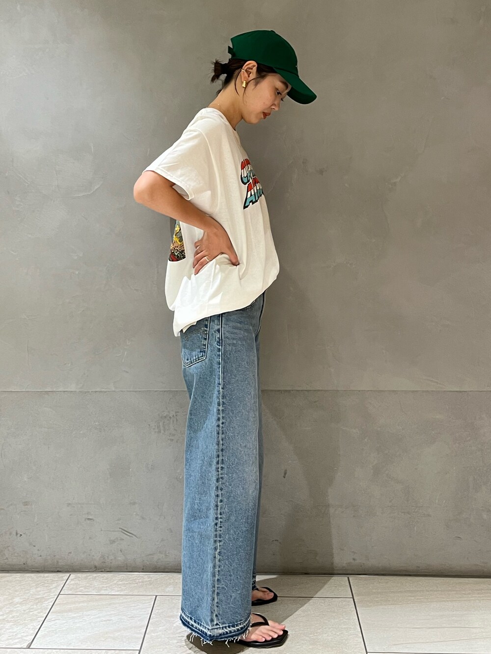 ホワイト系のTシャツ/カットソー、ブルー系のデニムパンツ、グリーン系のキャップを着用したレディースの夏コーディネートの5枚目の写真