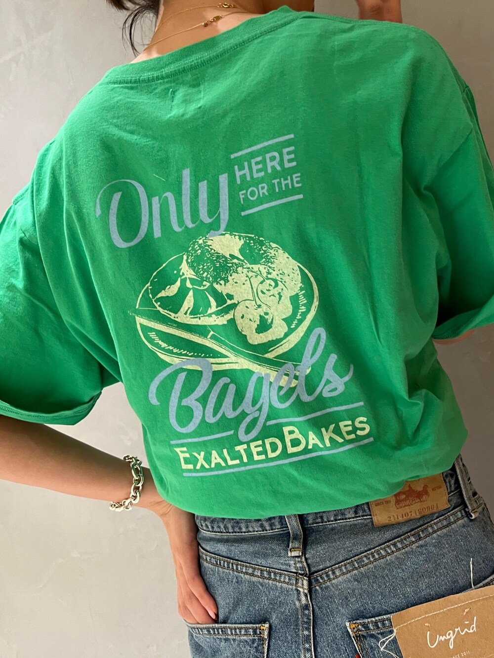 ブルー系のデニムパンツ、グリーン系のTシャツ/カットソーを着用したレディースの春コーディネートの6枚目の写真