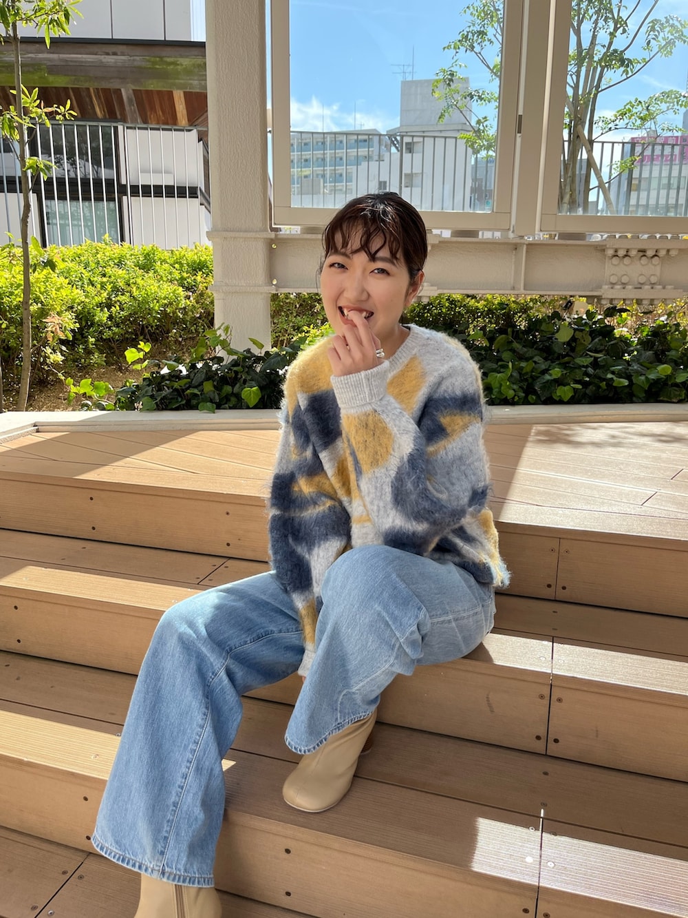 ブルー系のニット/セーター、ブルー系のデニムパンツ、ベージュ系のブーツを着用したレディースの秋コーディネートの4枚目の写真