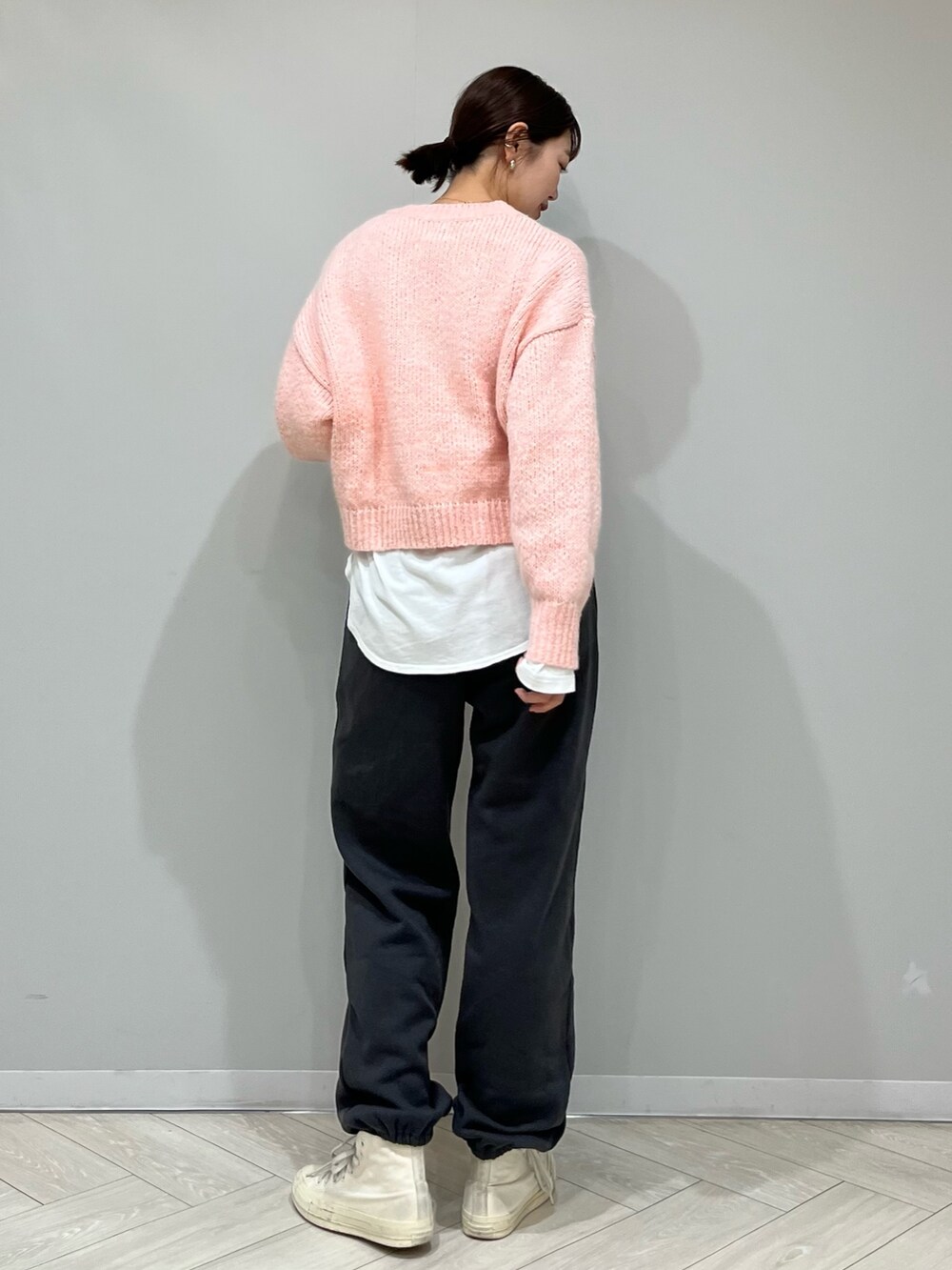 グレー系のスウェットパンツ、ピンク系のニット/セーター、ホワイト系のTシャツ/カットソーを着用したレディースの秋コーディネートの4枚目の写真