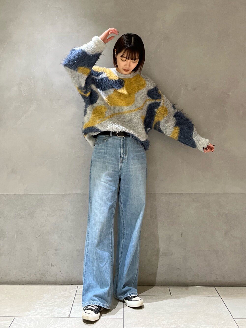 ブルー系のニット/セーター、ブルー系のデニムパンツを着用したレディースの秋コーディネートの4枚目の写真