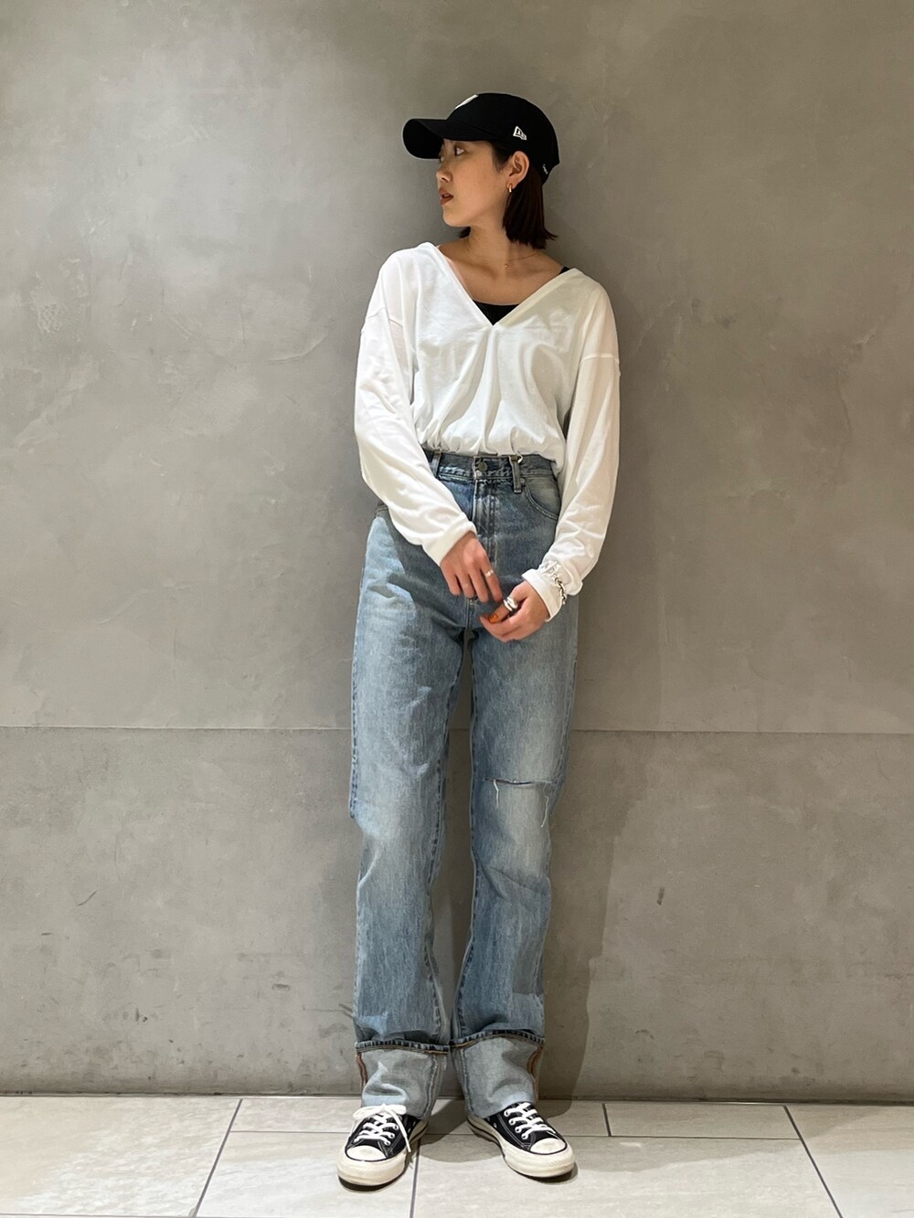 グリーン系のブルゾン、ホワイト系のTシャツ/カットソー、ブルー系のデニムパンツを着用したレディースの冬コーディネートの3枚目の写真
