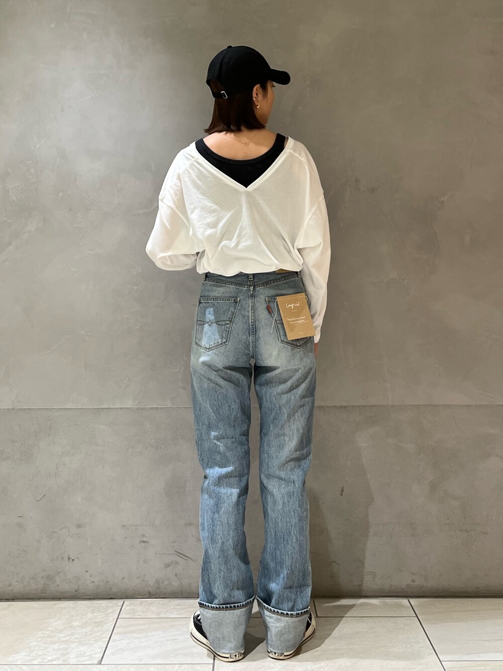 グリーン系のブルゾン、ホワイト系のTシャツ/カットソー、ブルー系のデニムパンツを着用したレディースの冬コーディネートの5枚目の写真