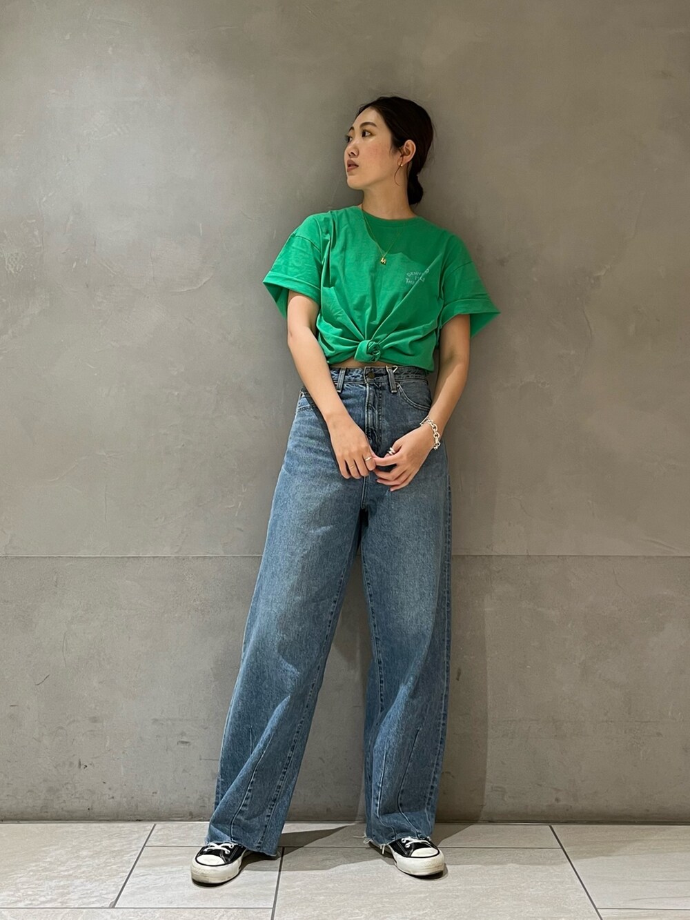 ブルー系のデニムパンツ、グリーン系のTシャツ/カットソーを着用したレディースの春コーディネートの4枚目の写真