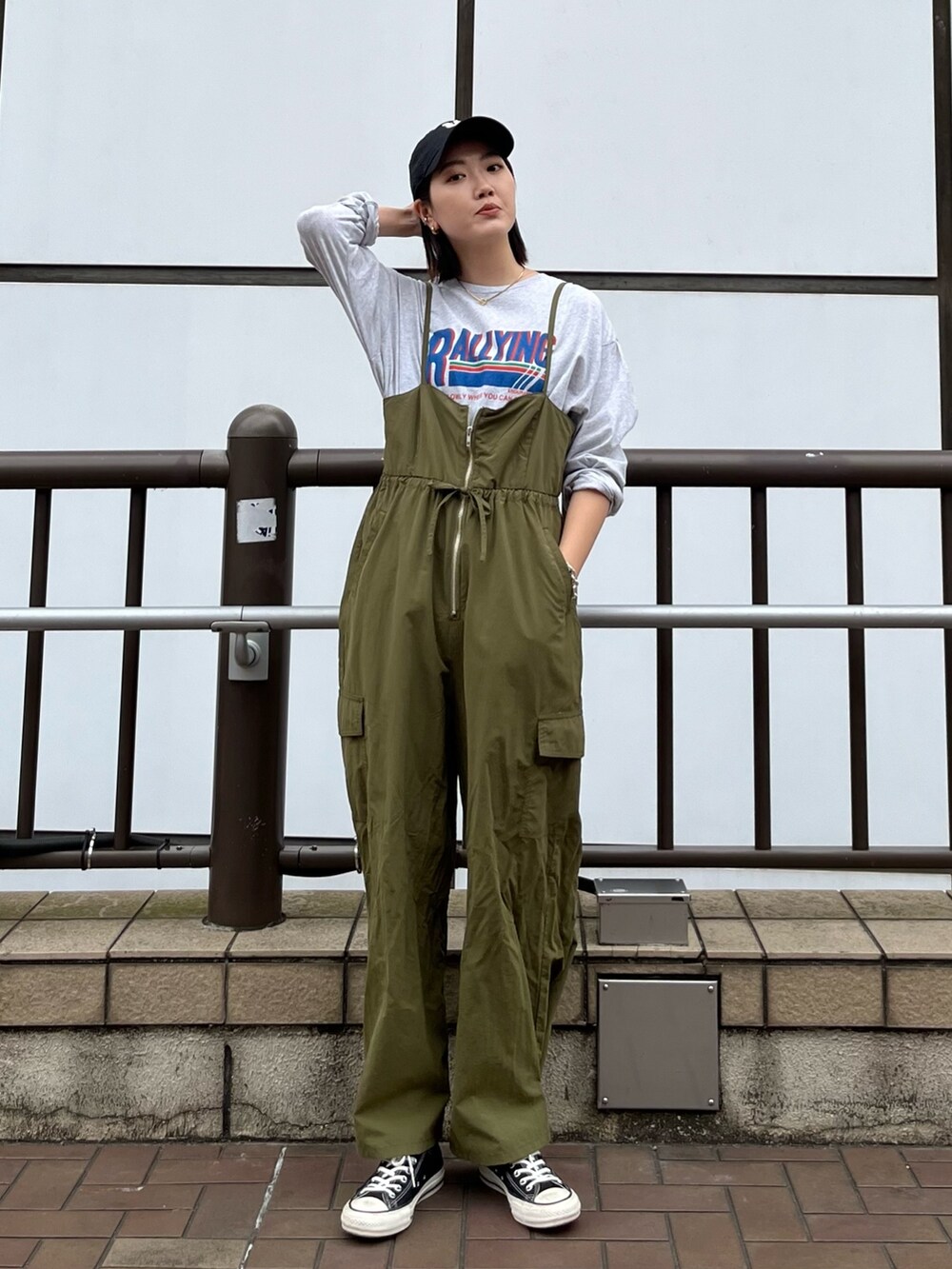 グリーン系のサロペット/オーバーオール、グレー系のTシャツ/カットソー、ベージュ系のステンカラーコートを着用したレディースの冬コーディネートの3枚目の写真