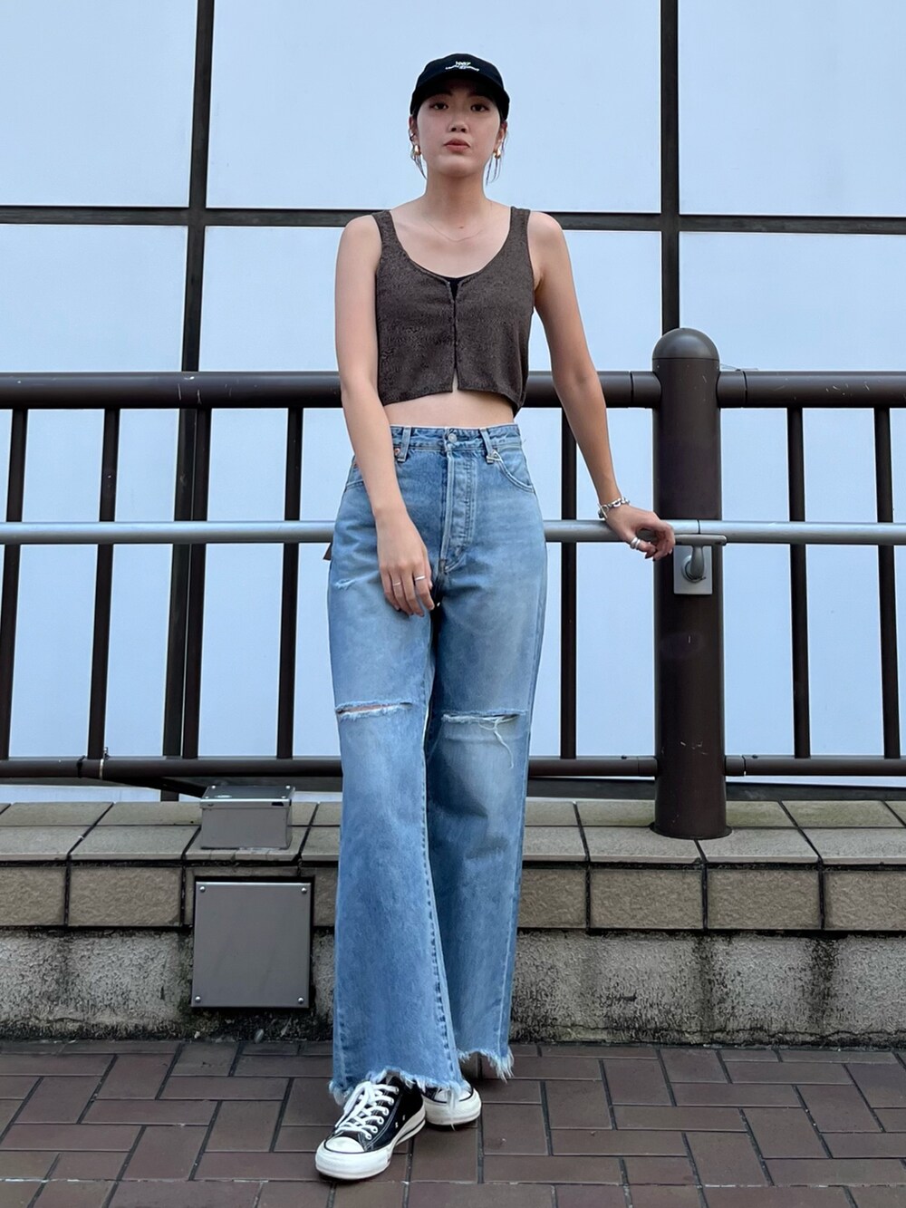 ブラウン系のベスト、ブルー系のデニムパンツ、ブラック系のキャップを着用したレディースの夏コーディネートの3枚目の写真