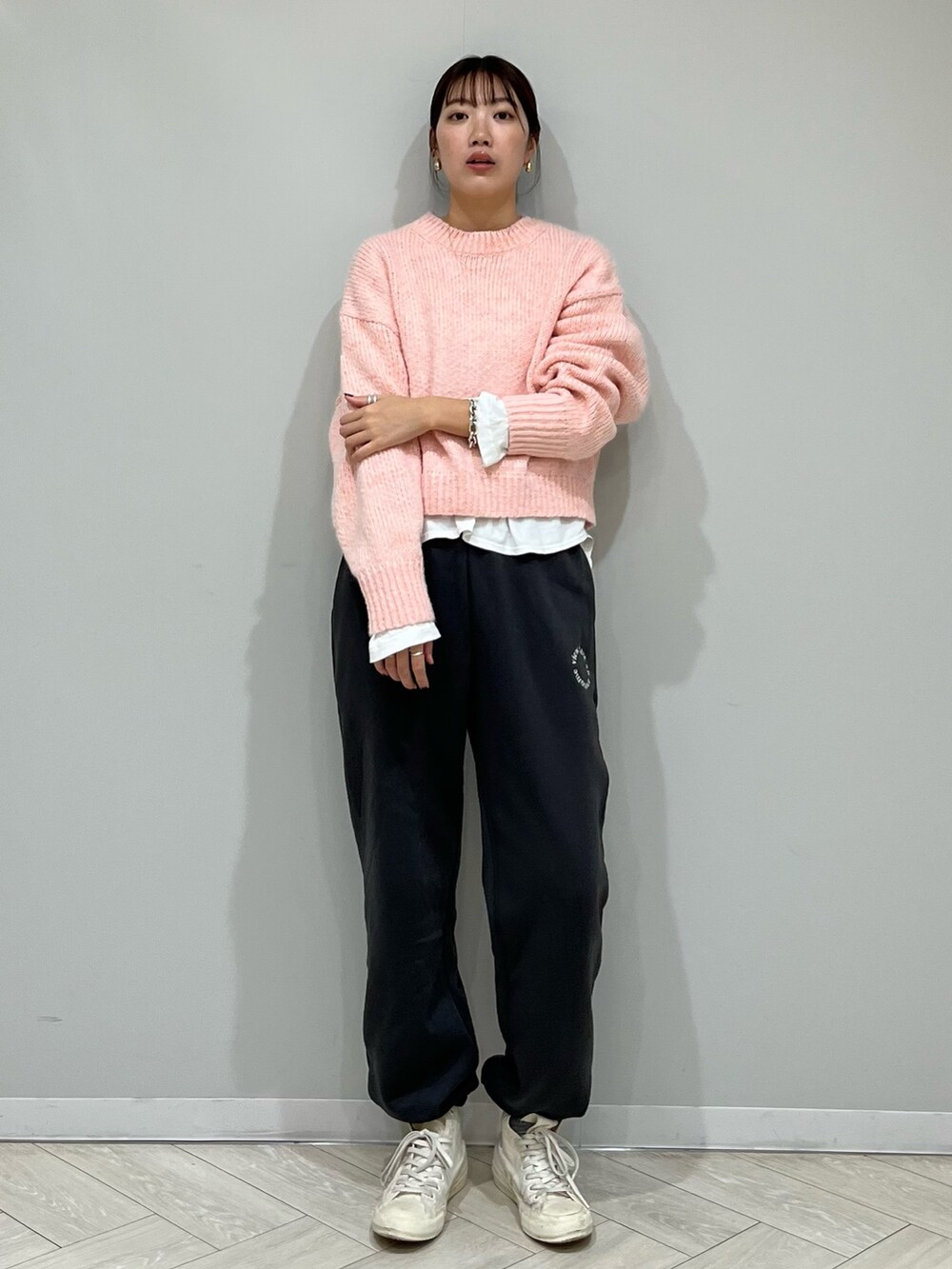 グレー系のスウェットパンツ、ピンク系のニット/セーター、ホワイト系のTシャツ/カットソーを着用したレディースの秋コーディネートの2枚目の写真