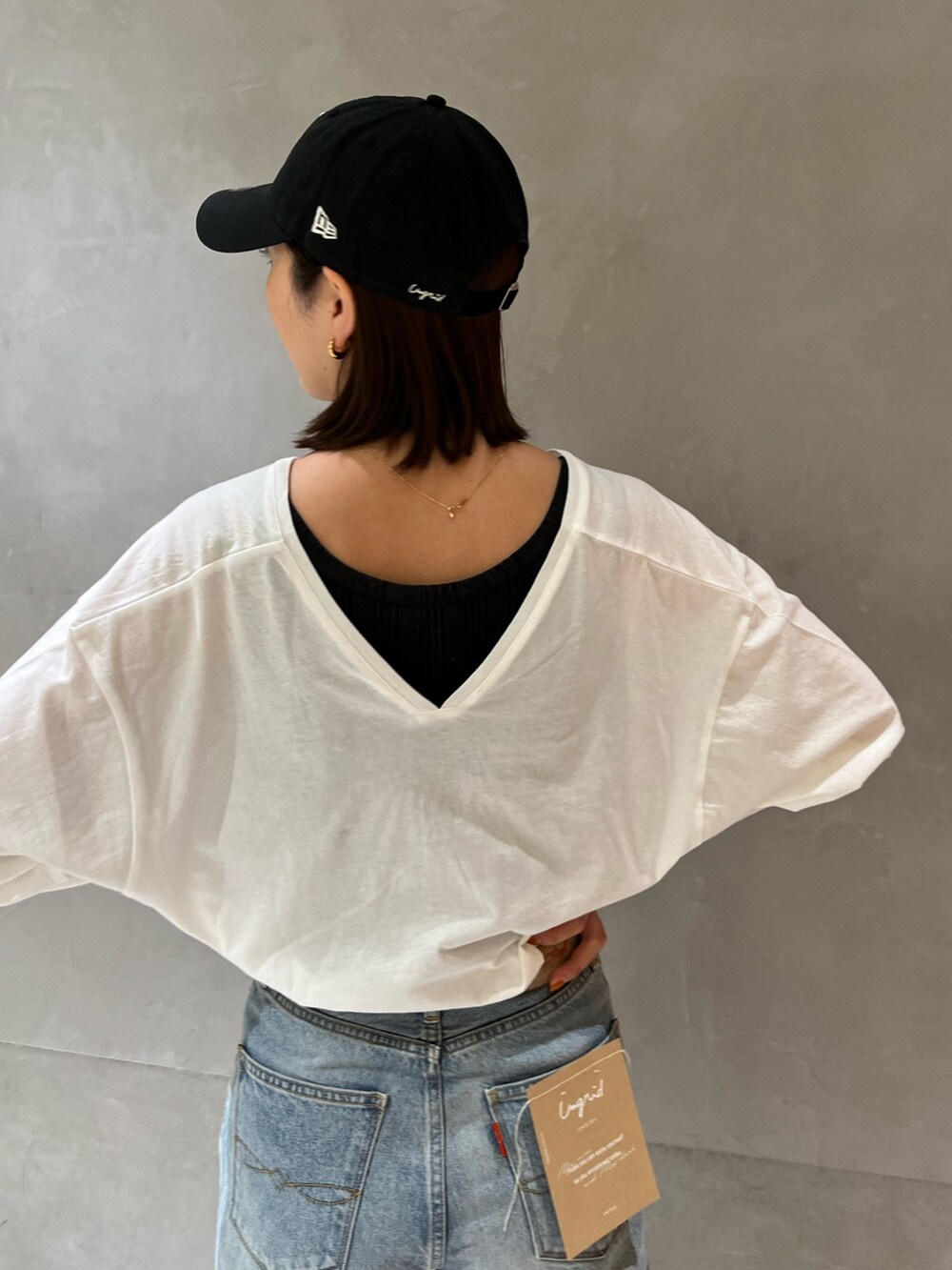 グリーン系のブルゾン、ホワイト系のTシャツ/カットソー、ブルー系のデニムパンツを着用したレディースの冬コーディネートの6枚目の写真